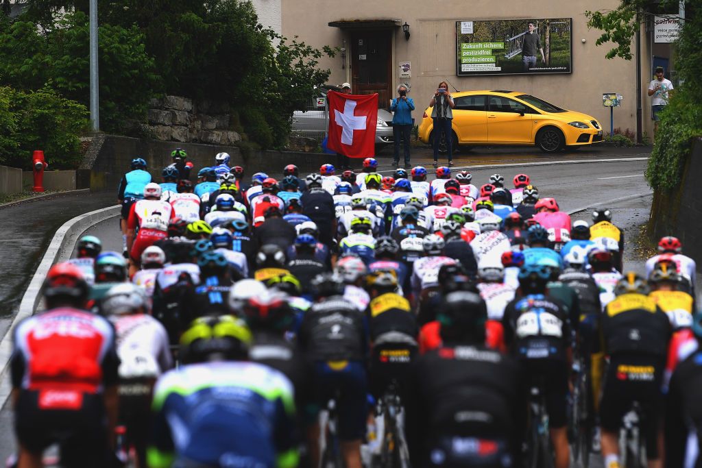 LACHEN SWITZERLAND JUNE 07 Fans The peloton during the 84th Tour de Suisse 2021 Stage 2 a 178km stage from Neuhausen am Rheinfall to Lachen Flag Landscape UCIworldtour tds tourdesuisse on June 07 2021 in Lachen Switzerland Photo by Tim de WaeleGetty Images