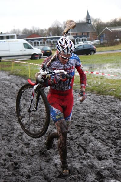 Tijmen Eising (Sunweb-Revor) shoulders his bike through the mud.