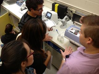 During a workshop, students at the University of Puerto Rico at Mayaguez genotype samples using a new Ion Torrent Personal Genome Machine at the newly established Caribbean Genome Center. Here, Jason Mitchell, a technician from the National Cancer Institute-Frederick works with students.