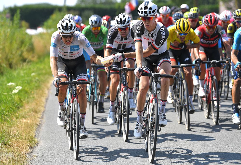 Chad Haga shares a bottle with teammate Soren Kragh Andersen during stage 9 at the Tour de France