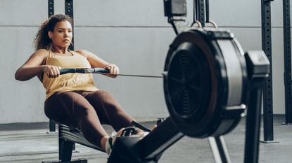 What are the muscles worked by rowing machines? Image shows person rowing