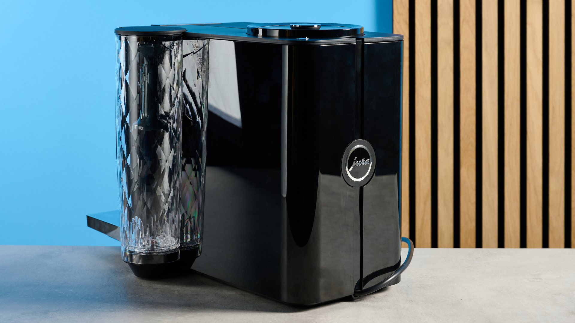 the jura ena 4 automatic coffee machine in piano black with a faceted water tank and bright screen