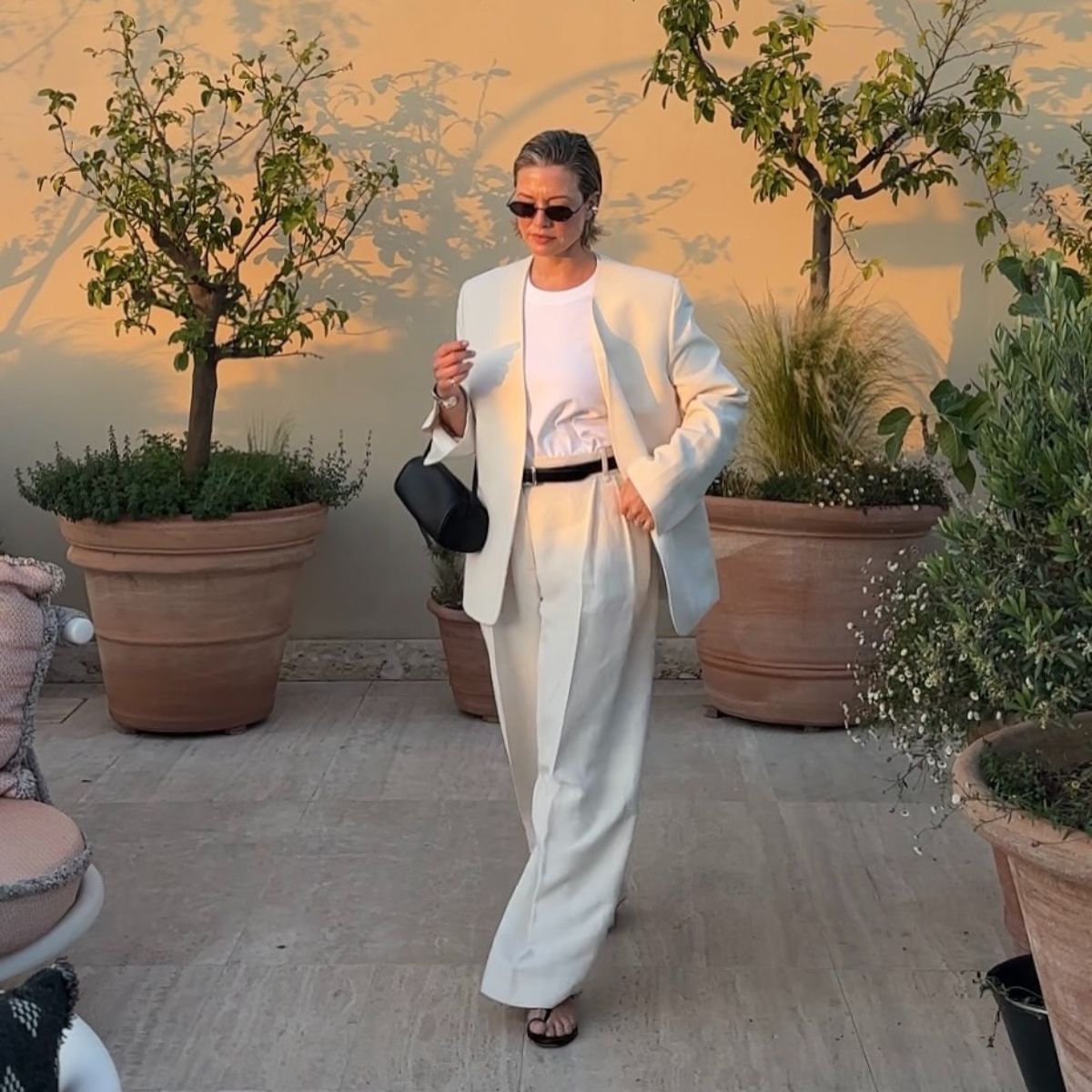 Alexis in white linen trousers and blazer