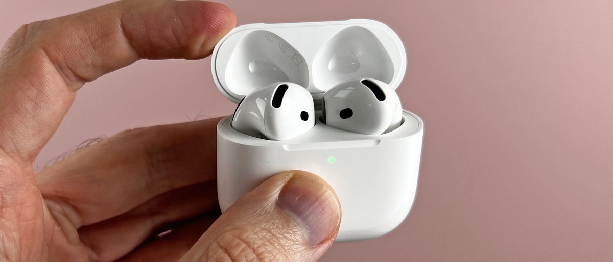 AirPods 4 in their case, held in a man&#039;s hand