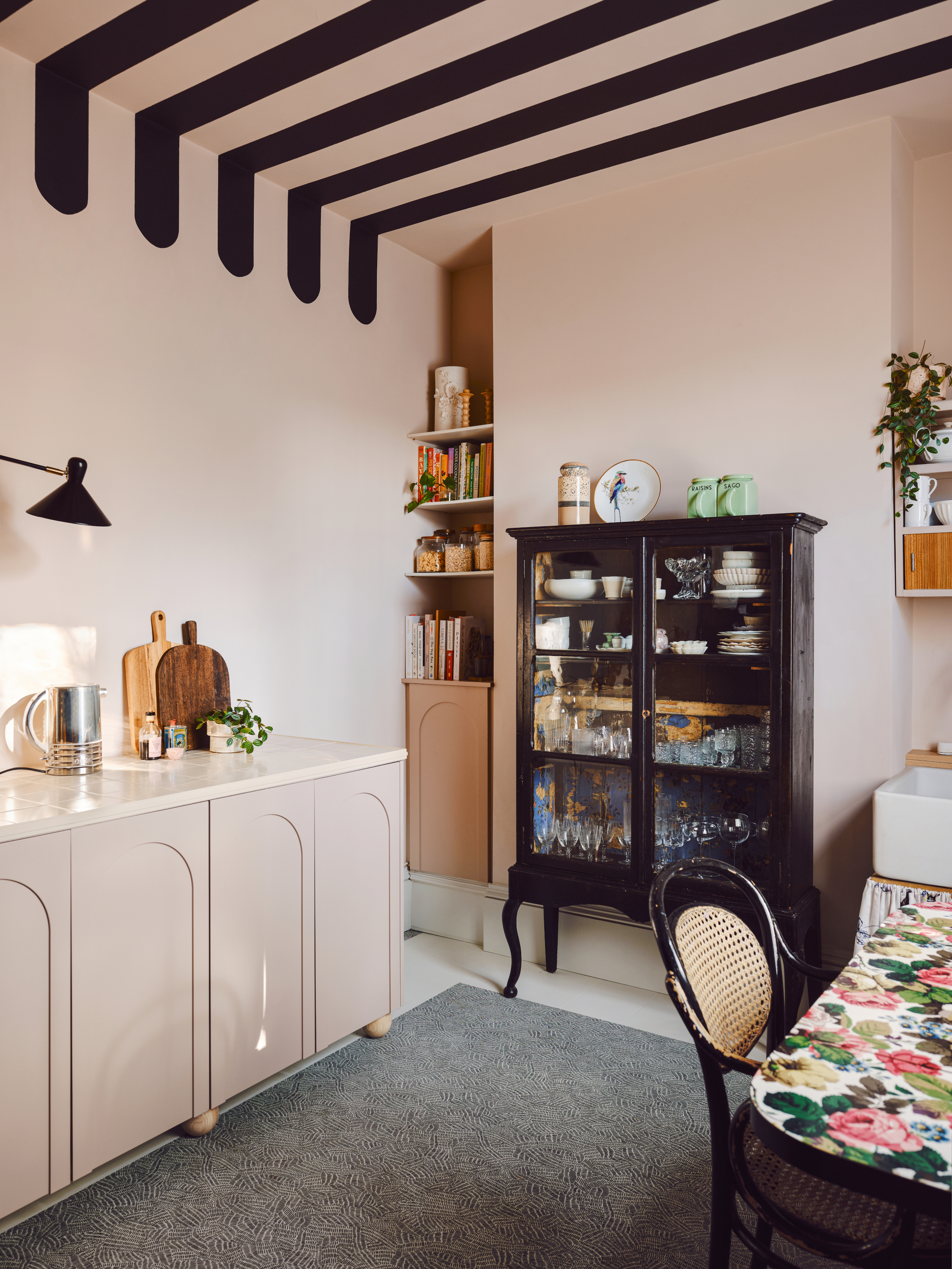 Pale pink kitchen with black stripes painted across the ceiling