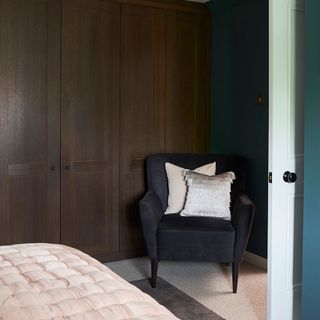 bedroom with dark wooden wardrobe and carpet flooring