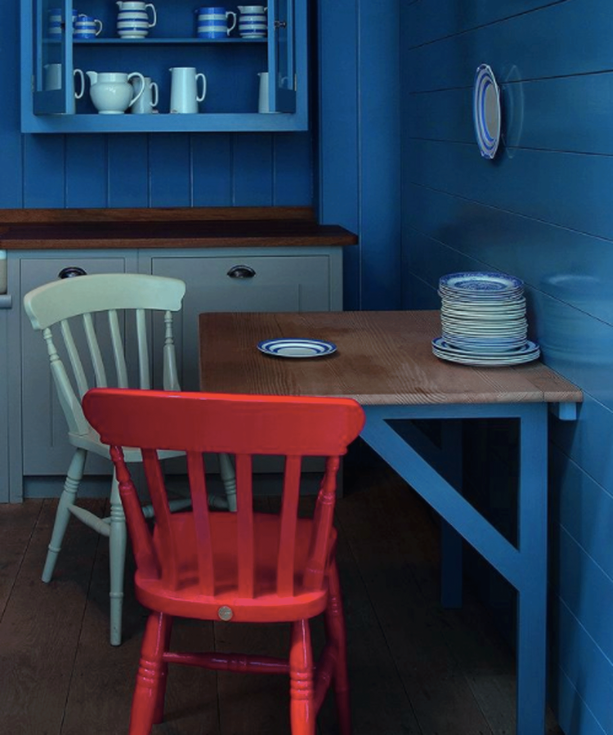 Small dining space with folding table and red and green chairs