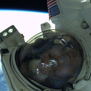 NASA astronaut Steve Swanson takes a photo of himself during a spacewalk outside of the International Space Station.