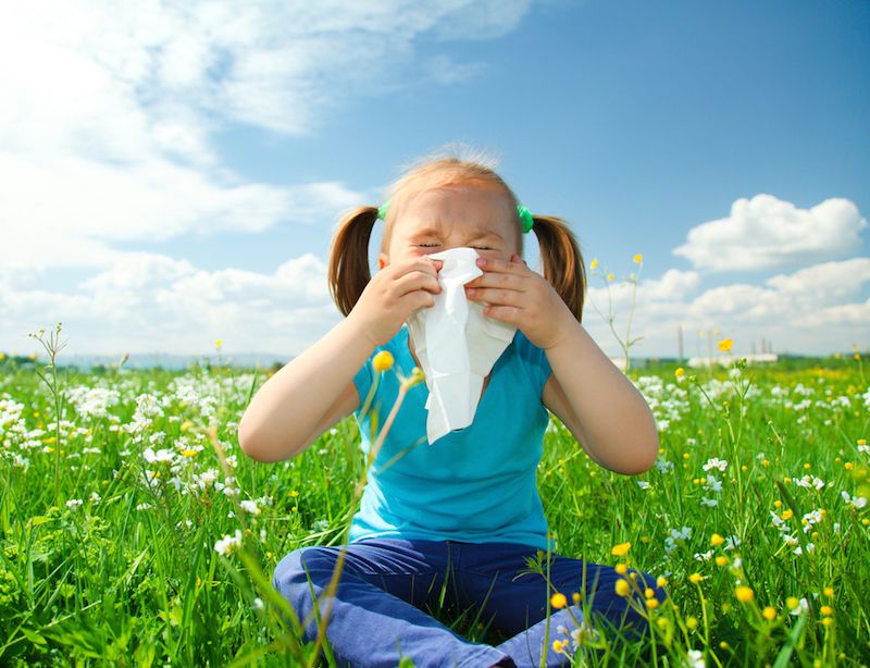 A little girl blows her nose.