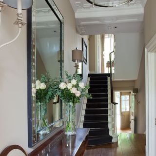 hallway with stair case and mirror