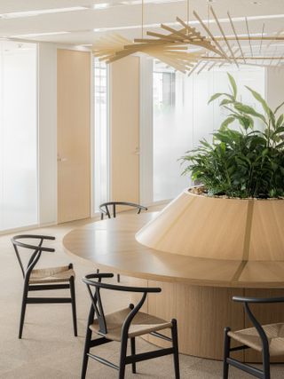 Circular wooden desk and black chairs at Cartier Japan HQ