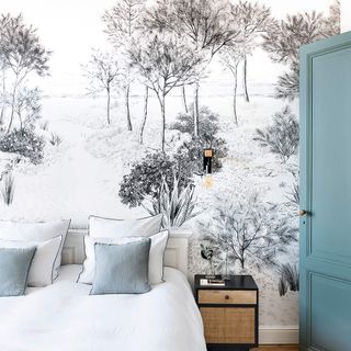 Bed in front of a mural with a snowy forest
