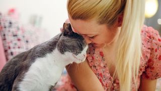 Woman cuddling with cat