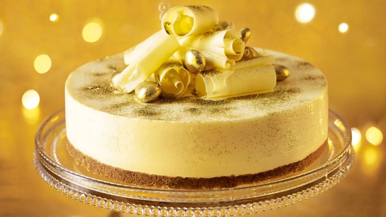 A white chocolate christmas cheesecake recipe presented on a glass cake stand