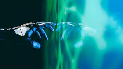 A close up of a mechanical hand touching a wall of blue and green light.