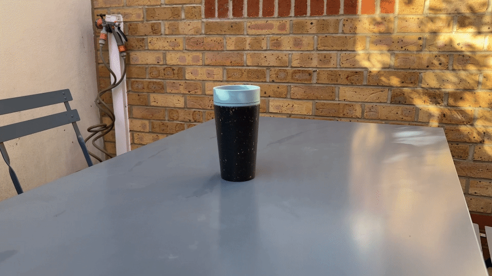 A GIF conversion of a spatial video showing a travel mug on a blue table