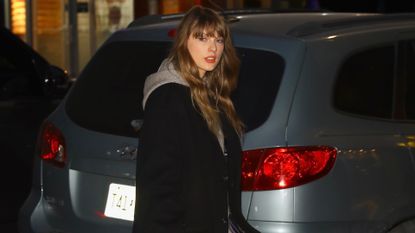 taylor swift in a cashmere dress by the row, boots by the row, and black coat