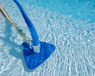 A pool vacuum in operation in a swimming pool