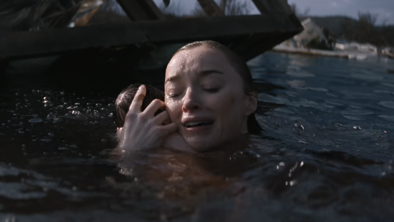 Lisa holding her newborn baby against her shoulder while in floodwaters in Netflix's Thrash