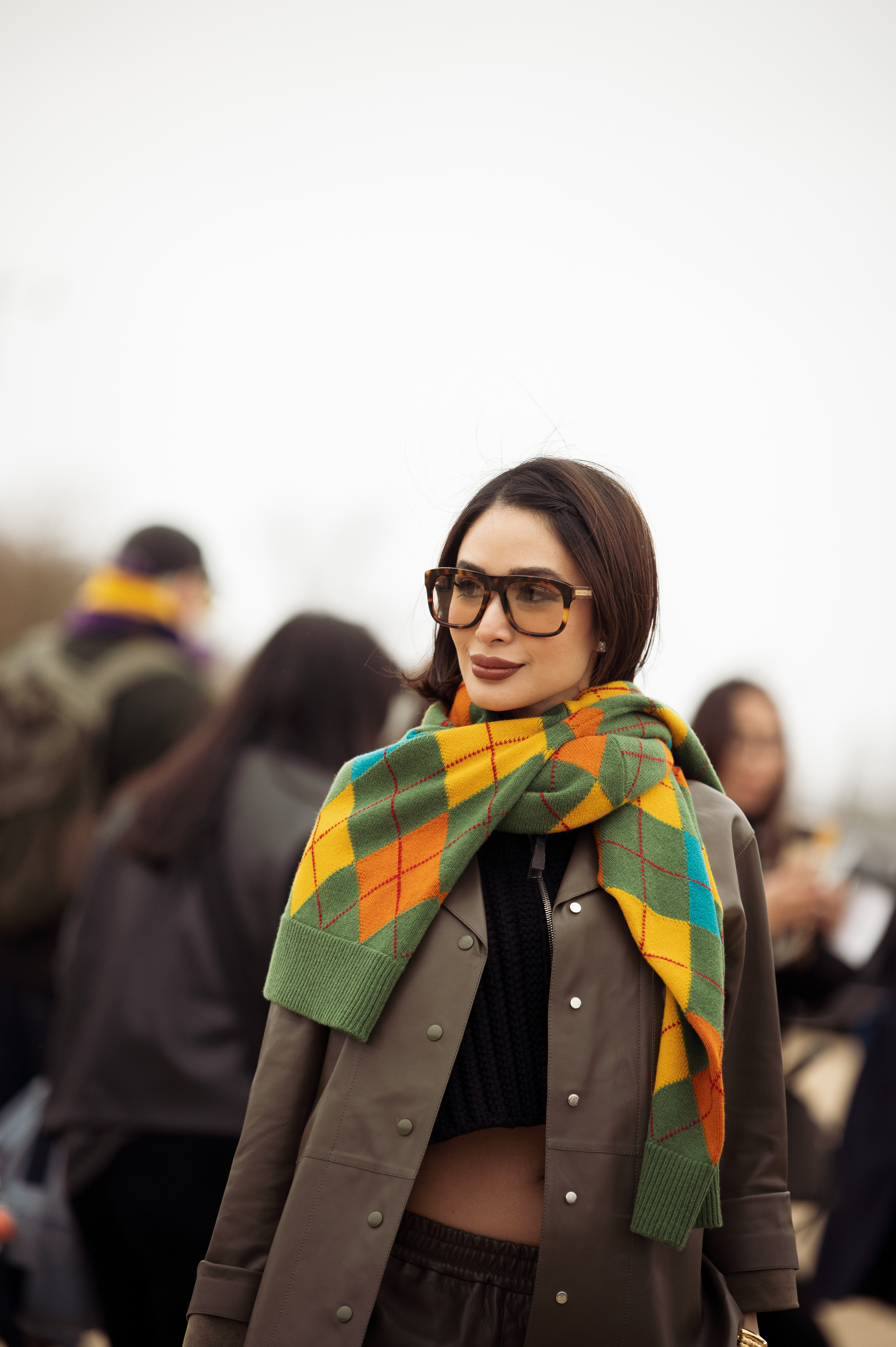 PARIS, FRANCE - MARCH 01: Heart Evangelista wears black cropped top, khaki leather shirt, yellow Loewe bag, green, yellow and orange sweater over her shoulders and yellow sunglasses outside Loewe during the Womenswear Fall/Winter 2024/2025 as part of Paris Fashion Week on March 01, 2024 in Paris, France. (Photo by Raimonda Kulikauskiene/Getty Images)