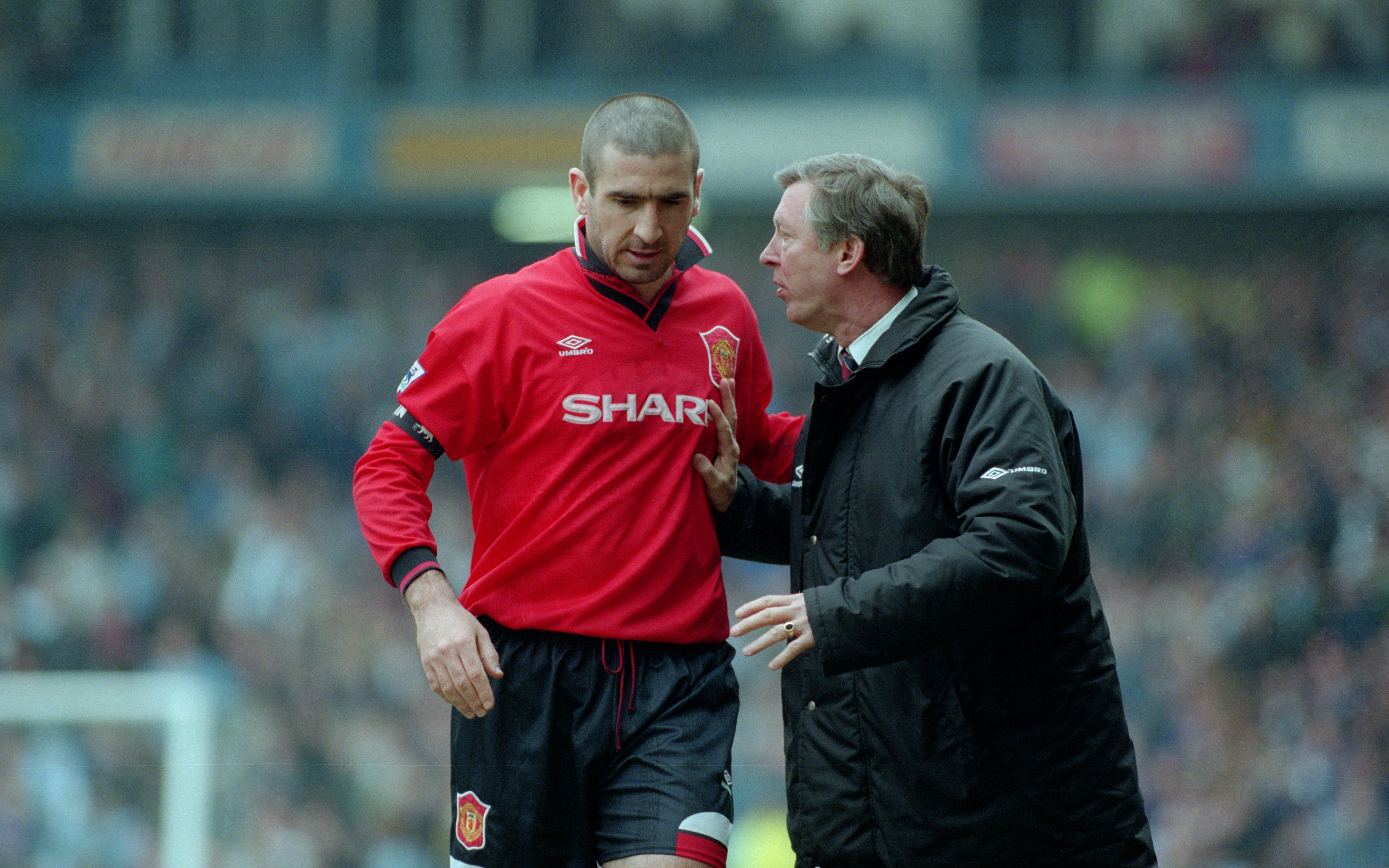 Alex Ferguson gives instructions to Eric Cantona during a Manchester United game against Manchester City in April 1996.