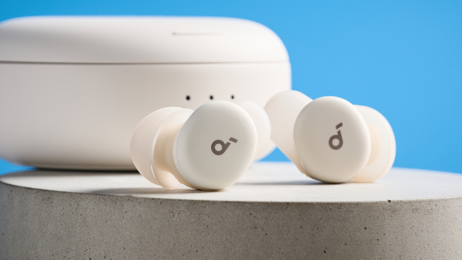 The Soundcore Sleep A30 earbuds on a stone plinth against a blue background