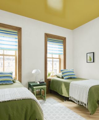twin bedroom with ceiling painted in gloss yellow paint