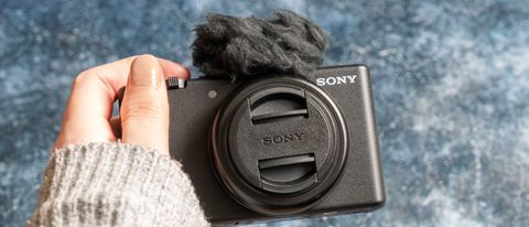 Sony ZV-F1 held in a womens hand with lens cap on