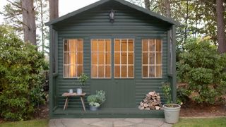 Garden shed painted forest green as part of a cottage garden idea makeover