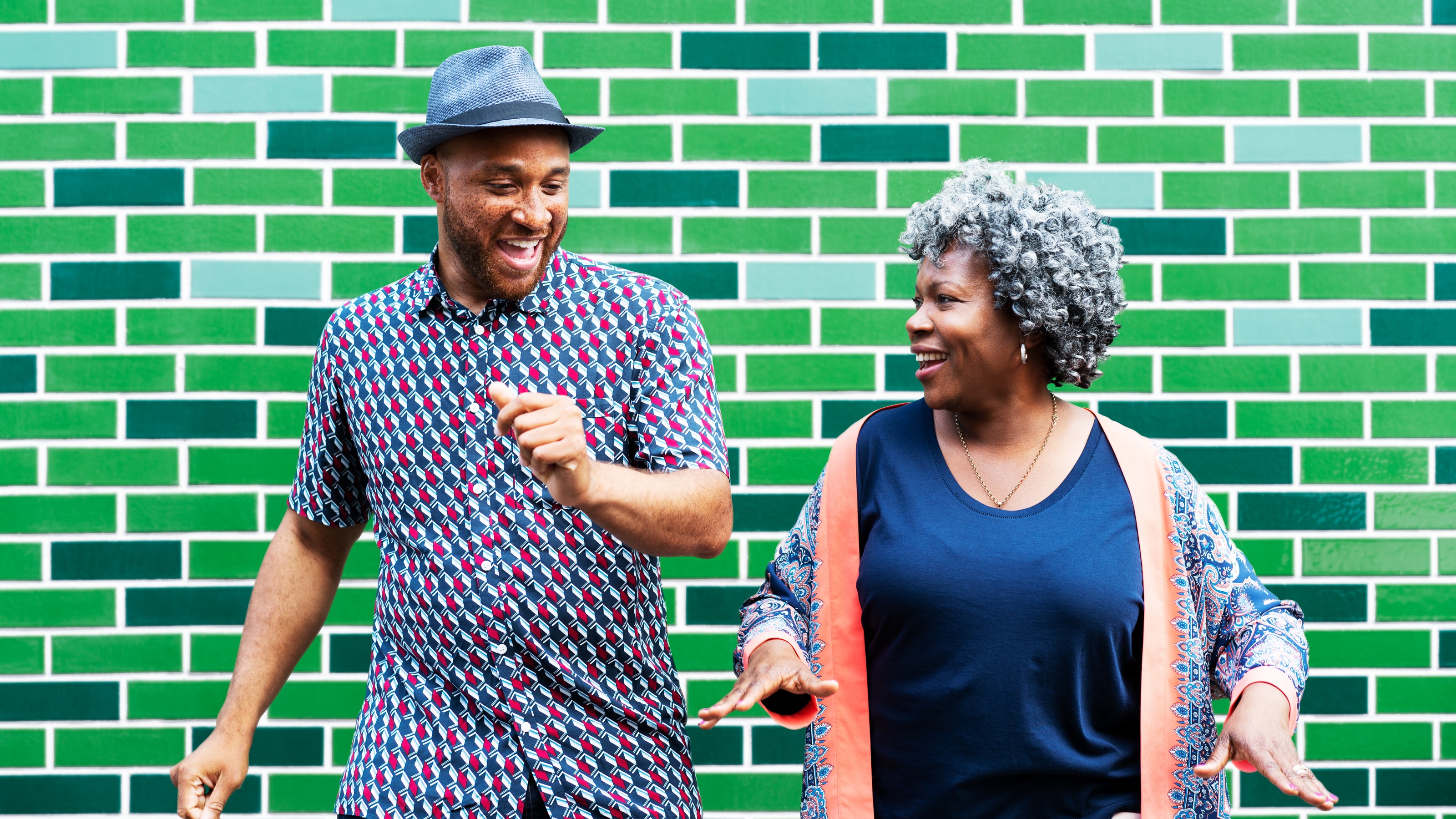 An older couple smile as they dance side by side.