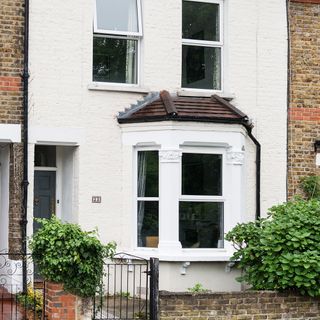 Front of white terraced house with bay window