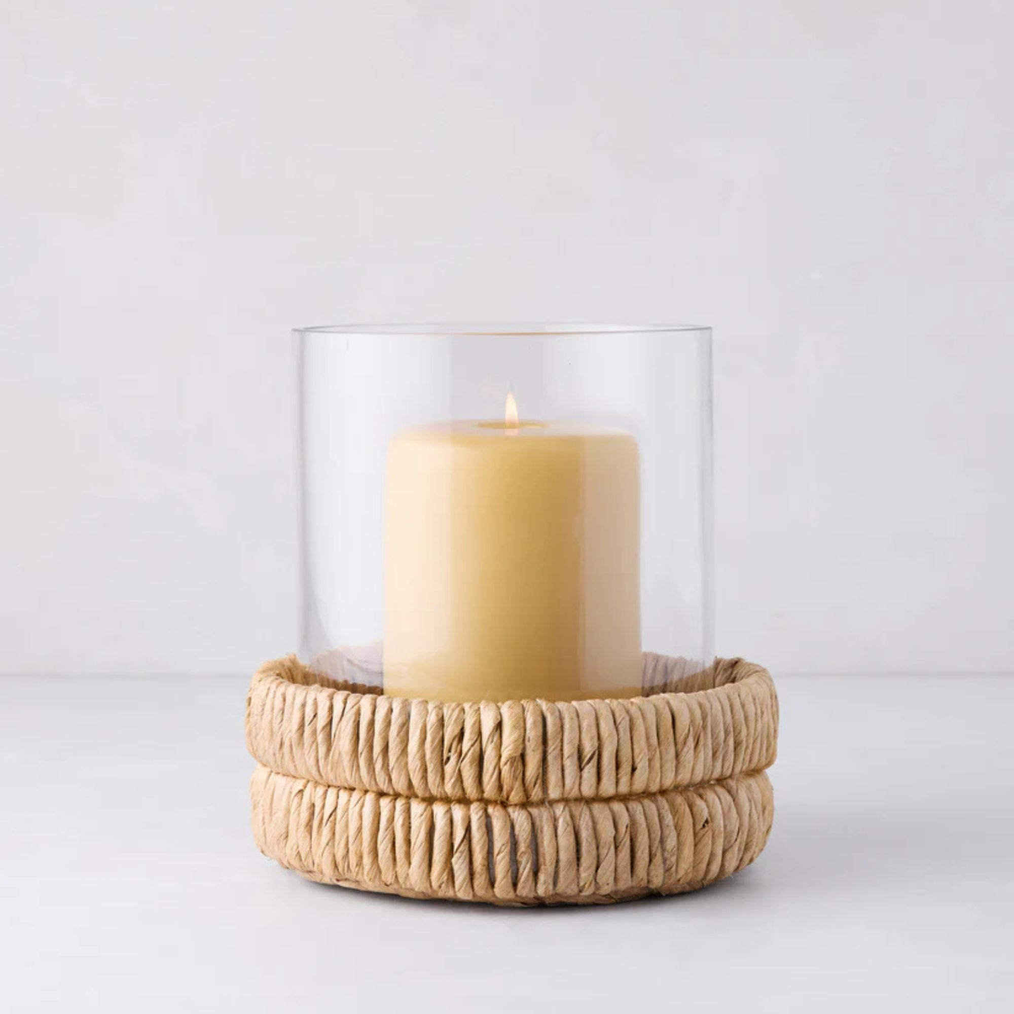 Glass hurricane jar with a woven banana bark base