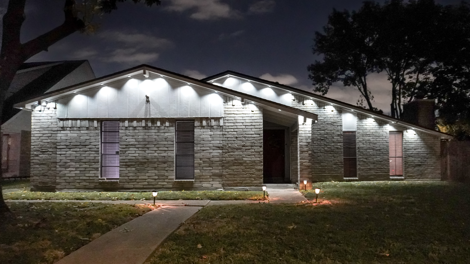 A wide shot of a house lit in white with Govee&#039;s Prism permanent outdoor lights