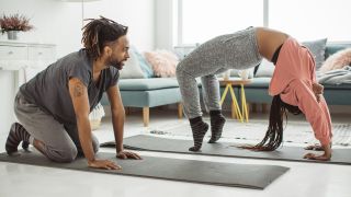 A couple do yoga at home on yoga mats