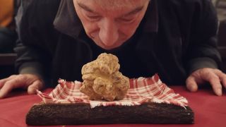 A man smelling a giant truffle in The Truffle Hunters