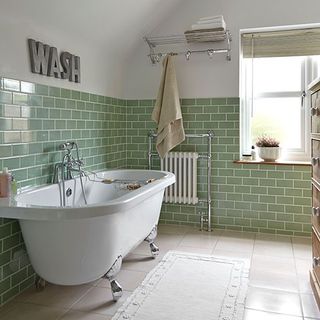 Green tiled bathroom with white bath and floor