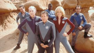 Screenshot from the movie Galaxy Quest. The 6 members of the Galaxy Quest crew are posing in a V-shaped formation in a canyon.