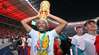 Mohamed Simakan of RB Leipzig holds the DFP-Pokal trophy on his head