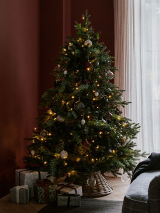 classic Christmas tree in rust coloured living room, Christmas tree skirt, wrapped presents