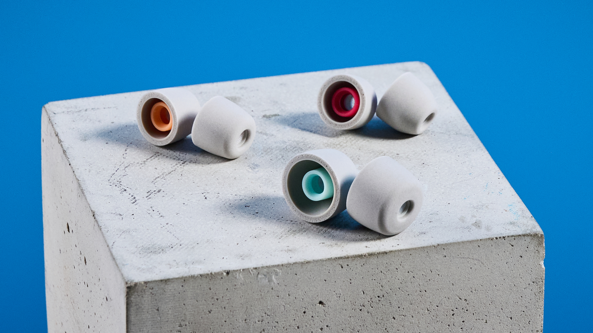 Sony WF-1000XM6 earbuds photographed in front of a blue background