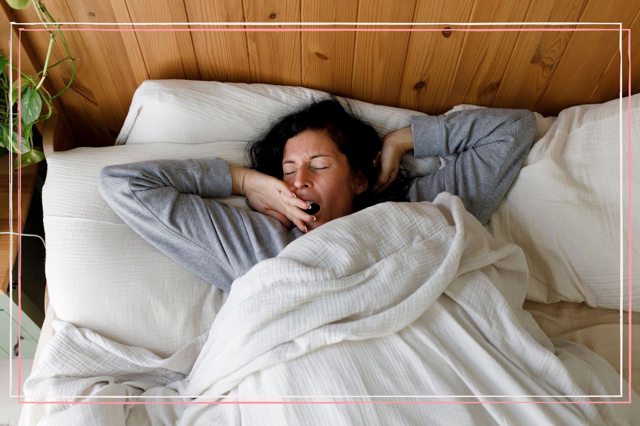 A woman yawning in bed