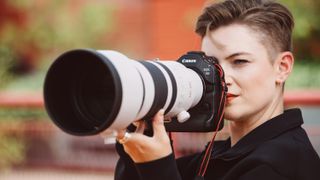 Canon EOS R1 camera held up to a person's face