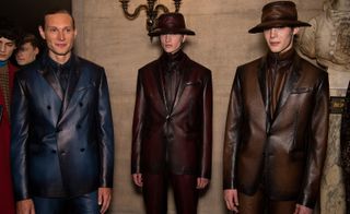 Three male models wearing clothing by Berluti.