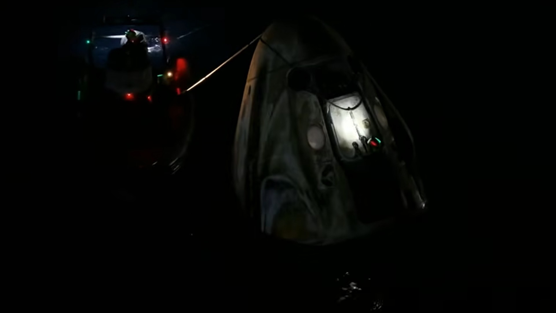 divers and boats approach a white cone bobbing in the ocean