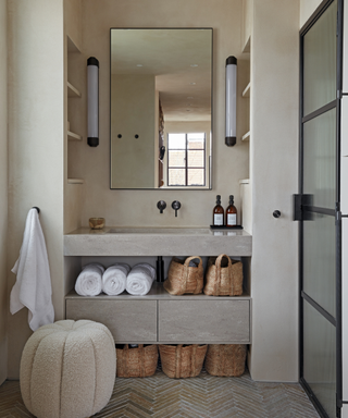 modern minimalist rustic bathroom with mirror and inbuilt sink and shelves and pouffe and crittal door to shower