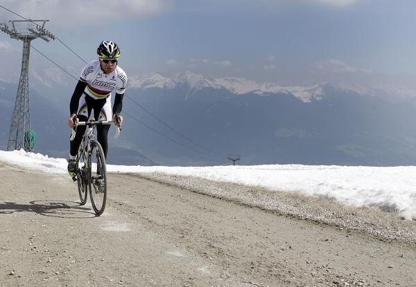 Snow-capped mountains in front of and behind Evans on the climb.