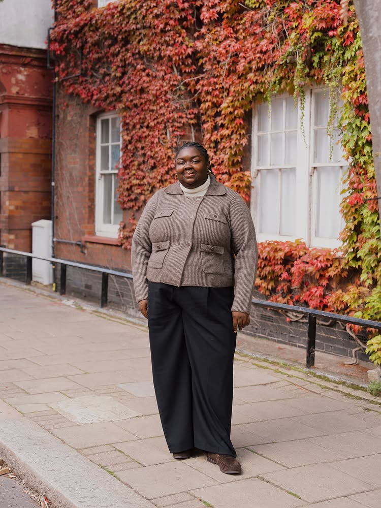 @abimarvel wearing a taupe cardigan, one of the key colour trends of 2025, with a black wide-leg trouser and suede loafers.