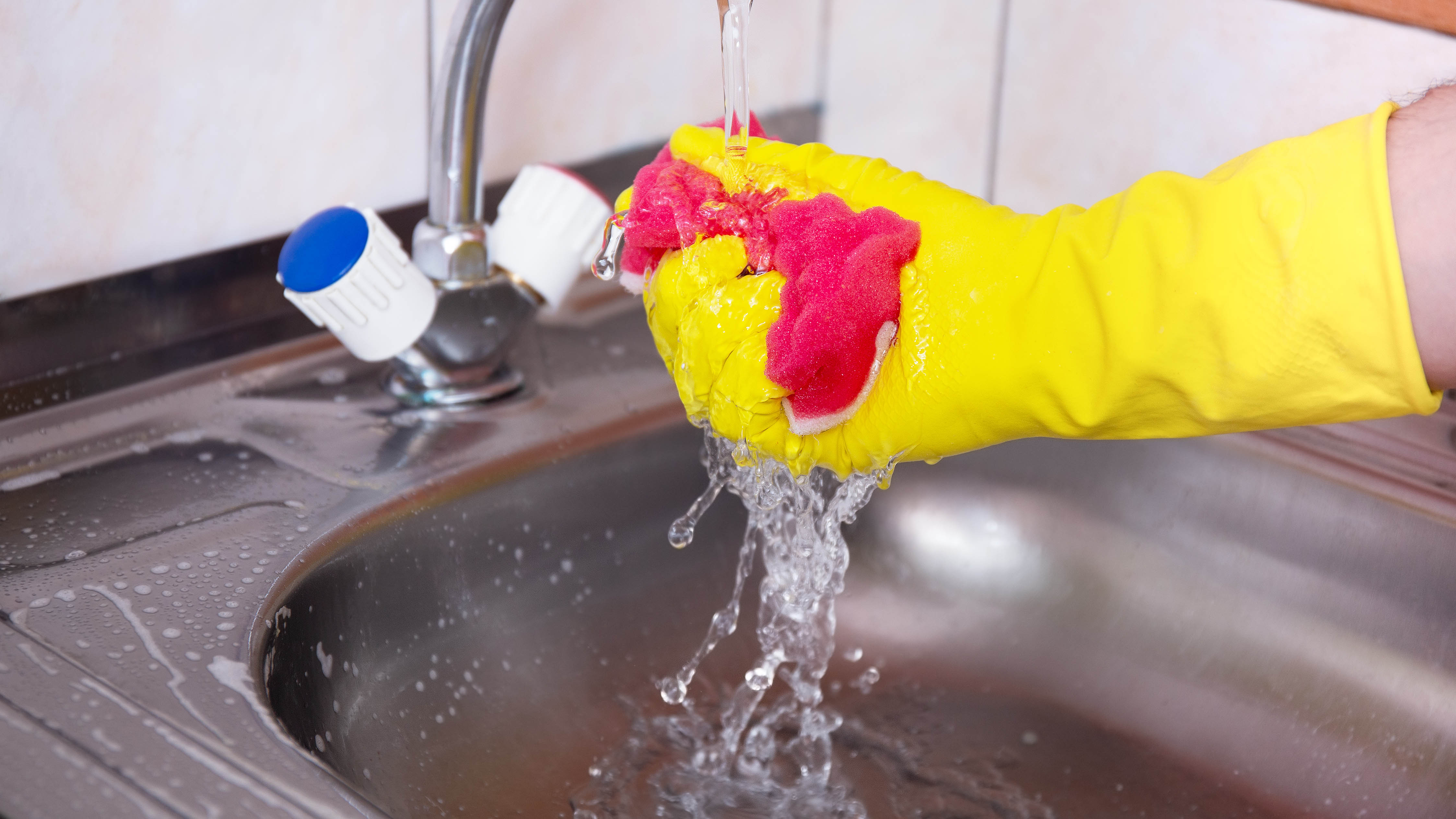 Cleaning kitchen sponge under water