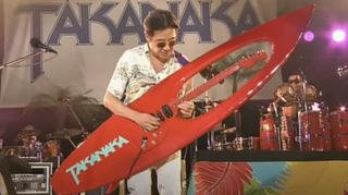 Masayoshi Takanaka plays a surfboard guitar onstage