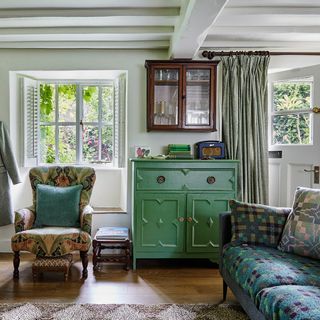 view of a cottage living room towards door and window with vintage furniture